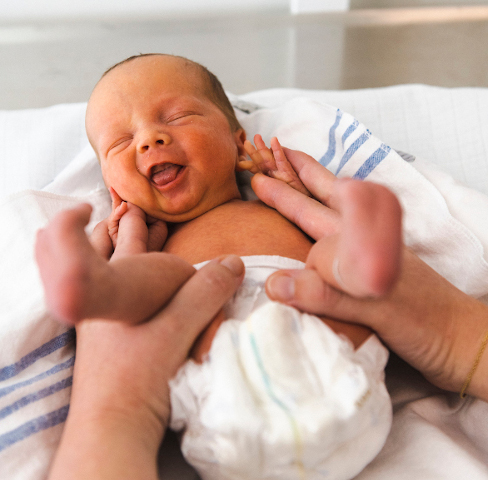 Nyfødt baby ligger med ble på puslebord