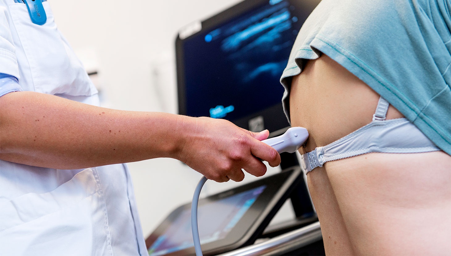 Læge lytter med stetoskop til patients lunger