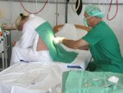 Læge giver epiduralblokade i ryggen på fødende, der sidder foroverbøjet